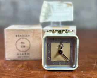 This lot features a vintage Bradley mechanical travel alarm clock, manufactured in Germany and is in good working condition.