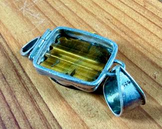 This lot features a vintage pendant with a carved piece of Tiger’s Eye in the shape of a turtle, wrapped in sterling silver. This pendant measures, 2.5” H and has a total approx. weight of 21.97 grams.