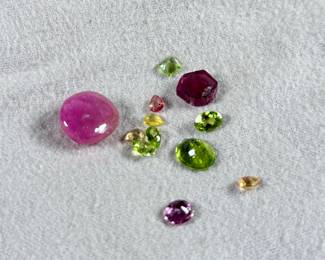 This lot features a collection of semi-precious gemstones including an earth mined sapphire, an earth mined ruby, and many others.