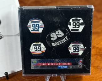 This lot features a vintage photograph of Wayne Gretzky held in a protective sleeve, along with a limited edition commemorative pin set.