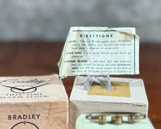 This lot features a vintage Bradley mechanical travel alarm clock, manufactured in Germany and is in good working condition.