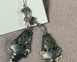 This lot features a pair of earrings by designer, Edgar Berebi. Edgar Berebi jewelry (1979–2001) is a highly collectible, American-made line known for intricate, limited-edition designs featuring 24K gold or silver plating, guilloché enamel, and Swarovski crystals. A Pratt Institute graduate, Berebi’s work often features detailed, artistic motifs ranging from Egyptian revival to whimsical animals and Christmas themes, commonly found as signed earrings, pins, and brooches.