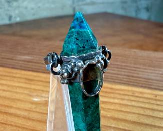 This lot features an antique pendant featuring Malachite wrapped in sterling silver. This pendant measures, 2.5” H.