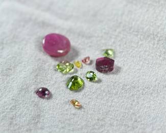 This lot features a collection of semi-precious gemstones including an earth mined sapphire, an earth mined ruby, and many others.