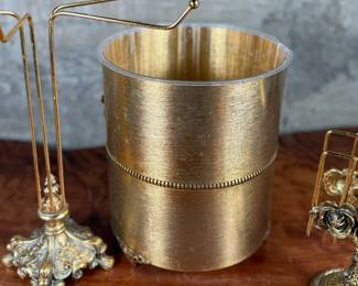 This lot features a curated collection of vintage Hollywood Regency-style bathroom accessories including a soap tray, a tissue holder, waste basket, and more.