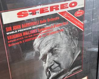 This lot features a professionally framed two-sided letter signed by composer, Ralph Vaughan Williams along with a LP by composer Sir John Barbirolli. Measures in frame, 31” H x 21.5” W.