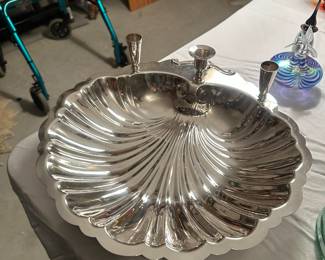 vintage Sheffield Silver Co. clam shell footed serving dish features a scalloped edge and is designed with three integrated candle holders. It is commonly used for serving seafood cocktails, dips, or as a decorative centerpiece. 
