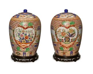 2047 A pair of Chinese porcelain covered vases 20th century Each bearing a red apocryphal reign mark to underside; one with a partial Macau sticker Each lidded vase with floral bunches within cordiform friezes and a floral medallion ground, raised on a carved wood stand 2 pieces Each overall: 15.25" H x 9.5" Dia. Estimate: $200 - $300