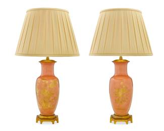 2085 A pair of gilt porcelain lamps Marbro Lamp Company, mid-20th century Underside of foot impressed in relief: MARBRO The gilt-decorated matte salmon-glazed bodies each mounted as a two-light table lamp, with gilt-metal mounts, surmounted by a pleated fabric shade, electrified 2 pieces Each lamp: 34.5" H x 6.75" W x 6.75" D; Each shade: 13.25" H x 20" Dia. Estimate: $400 - $600