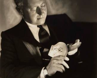 2370 George Hurrell (1904-1992) Portrait of Cecil B. DeMille holding "a pearl like a fish" Photograph on paper From the edition of unknown size and date Embossed in the lower margin: Hurrell; typed on a label verso: "4047 - 'A pearl like a fish' is the rarity shown by Cecil B. DeMille, / Metro-Goldwyn-Mayer producer-director. The "fish pearl" was formed / when an oyster swallowed a small eel. Being unable to digest it, he / formed what is said to be the only pearl of its kind in existence." Image: 9.125" H x 7.25" W; Sight: 9.75" H x 7.625" W Estimate: $200 - $300
