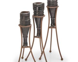 2062 Three enameled metal vessels 20th century or earlier The cast metal vessels, each set in a metal stand 3 pieces Tallest overall: 37.5" H; Each urn approx.: 18" H x 6" W x 5.5" D; Tallest stand: 29" H x 13" Dia. Estimate: $100 - $200