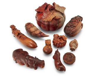 2051 A group of Japanese carved wood vegetable and fruit form boxes Late 19th/20th century Comprising various gourds, a pinecone, and a pomegranate, together with a carved model of a hippopotamus 9 pieces Largest: 5.25" H x 7.25" Dia.; Hippo: 2.25" H x 6.75" W x 3.125" D Estimate: $500 - $700