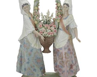 2030 A Lladro porcelain 'The Floral Offering' figural group 1985 From the edition of 3,000 With blue printed factory mark / Hand made in Spain / © Daisa / 1985; signed and numbered: Escul. J Huerta / No 550 / Decor: V Navarro; impressed model number 1490, further impressed and incised: My-10 K / 91 / 3 [in a diamond cartouche] Sculpted by Juan Huerta and decorated by Victor Navarro, modeled as two women in flowing dresses hoisting a large floral display 15" H x 10.5" W x 4.625" D Estimate: $600 - $900
