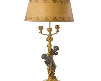 2089 A Louis XVI style parcel gilt bronze figural three light candelabra 20th century Mounted as a table lamp, the standard cast with two putti on a coved tripartite alabaster base, all raising a gilt decorated flaring circular tole shade, electrified Overall: 34.75" H x 15.5" Dia. Estimate: $200 - $300