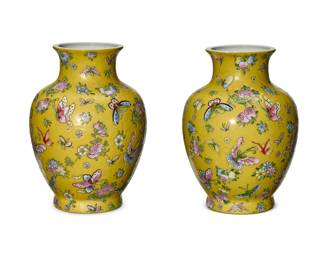 2045 A pair of Chinese Famille Jaune porcelain vases 20th century Each bearing red apocryphal reign mark to underside Each footed vase depicting butterfly, chrysanthemum, and fruit motifs 2 pieces Each: 12" H x 9" Dia. Estimate: $200 - $300