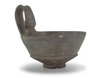 2114 An Etruscan Bucchero pottery kyathos 7th-5th century BCE or later The drinking cup with incised accents to handle and body 5" H x 5.375" W x 6.625" D Estimate: $400 - $600