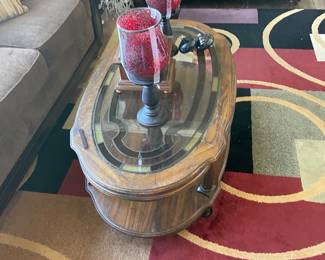 Traditional solid wood coffee table featuring oval design with beveled glass insert tabletop