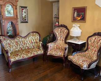 Victorian style setee with carved wood frame and traditional upholstery button ruffed floral tapestry velvet fabric, carved cameo back with cabriole legs. Ladies and gentlemen parlor chairs with carved double rose detail, cabriole legs and button tufted floral tapestry velvet fabric
