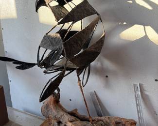 sculptural art piece depicting a bird, likely a falcon or eagle, created from scrap or recycled metal