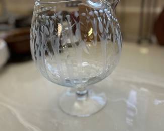 Vintage footed glass pitcher with pinched spout for mixing cocktails, water or juice has etched floral/botanical patterns