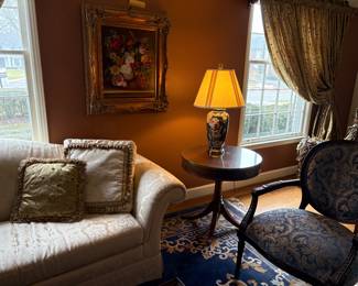 Curved arm loveseat, round side table, upholstered armchair (2), gold-leaf framed acrylic, porcelain lamp and oriental wool area rug