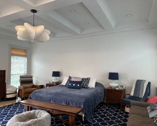 This image is for staging purposes only to showcase the bench, rug, leather recliner, couch and white lamps. As well as the cloth covered woven wicker ottoman next to the leather recliner.