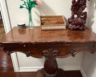 Antique Wooden Claw Foot Games Table. Claw feet anchors the pedestal base with traditional moldings and a stately presence. A Flor Di Li is carved into the center of the curved apron. Top flip out for dining, working or playing games. Center is railroaded with light wood panels 