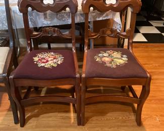 Mahogany side chairs carved rose petal backs with tapestry needlepoint upholstered seats with one in a floral and one a fruit design