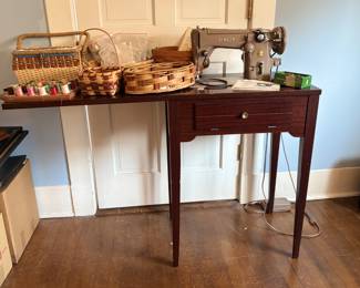 Beautiful vintage Singer sewing machine in sewing table with notions and baskets
