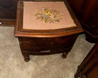Antique wooden bedside commode with needlepoint top.