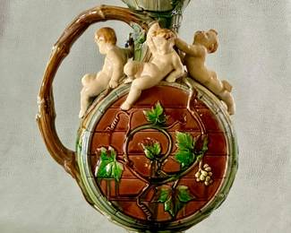Another view of the stunning rare 1861 large hand-painted majolica ewer, 14-1/2" tall, marked Minton, known as the Palissy jug, modeled by French sculptor Hughes Protat with impressed modeler’s initials HP under handle; formed as barrel, the neck adorned with 4 festive cherubs, circular body decorated w/raised green brown vine tendrils, deep turquoise liner, prof. repair to handle.
