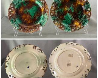 Pair of antique Wedgwood majolica "Heron" dessert plates designed by Théodore Deck, moulded center design of a crane, dragonfly, and cattails, pierced border, colored in mottled greens, yellows, and browns, with cream color backplate. 9-inch diameter, impressed Wedgwood mark and letter date code ODC (10/1869) and impressed letter T.