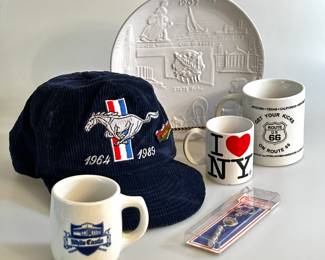 Commemorative Mustang baseball hat, an Oklahoma centennial plate, coffee mugs from White Castle, Route 66, and NY