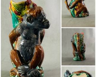 A charming antique majolica figural pitcher, 8-3/4 inches high, molded figure of a monkey with hands behind his back, bright glazed/hand-painted, body in shades of gray and brown, molded green leaves on his back w/shading of yellow and red, liner of deep pink; circa 1880-90, American, no identifying potter marks. 