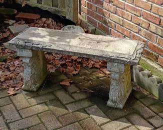 A vintage molded cement top with vine and leaf design, resting upon pair of molded cement legs, also with vine and leaf design. Bench in three parts.