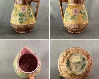 An antique Griffin, Hill & Smith majolica pitcher circa 1880-1890, with butterfly spout, basketweave base and wild rose pattern on body, hand-colored in pale yellow ground with pink flowers and green leaves; brown basketweave trim and butterfly, cobalt blue top rim, lavender/pink liner. Marked with double circle trademark of GHS Etruscan Majolica