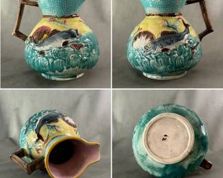 Antique majolica pitcher hand-colored with lustrous glaze; high relief grey fish with brown fins swimming in molded turquoise waves, white and brown seashells, yellow background and rim, turquoise neck, lavender liner and brown handle. English, potter unknown, c. 1880, number 20 in black overglaze on the base.