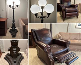 A Victorian-style 4-arm indoor lamp post with frosted globe shades and lion head accents, and a Bradington Young dark brown leather wingback pushback recliner or barcalounger with nailhead trim
