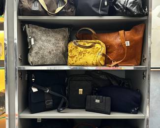 A selection of handbags, purses, and totes ranging from casual nylon bags to structured leather and fabric purses including a Francesco Biasia brown leather satchel shoulder bag with braided handles, a 90s vintage Brighton black leather clutch/wallet croc embossed with silver accents, and a Guess black leather crossbody handbag