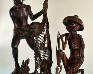 A pair of hand-carved Balinese/Indonesian wooden figures, a fisherman with net and a farmer carrying basket