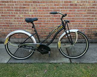 A Giant Simple cruiser bike, featuring a distinct black frame decorated with yellow and blue flame graphics and chrome fenders