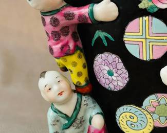 Close up view of the vintage Chinese famille noire glaze "fertility" vase with sculpted figures of climbing children