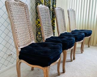 A set of 4 matching cane-back chairs with deep blue upholstered seats