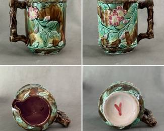 An antique majolica small jug c. 1880-90, jug done in rustic styling, dark textured looking body of brown/dark moss green, raised overlay of green leaves and dogwood pink flowers and buds, brown branch handle, hand colored with glaze, lavender liner. 5-3/4" H, American, potter unknown, painted letter Y in deep ink underglaze on the base.