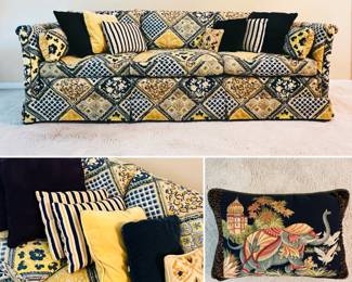 A three-seat rolled arm sofa in blue and yellow patchwork design upholstery, shown with group of decorative throw pillows