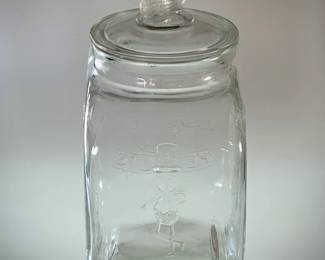 Another view of the vintage large Pennant Salted Peanuts countertop store display lidded jar, with various poses of a peanut figure wearing top hat, and a peanut finial on the lid