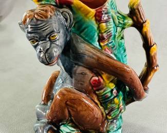 Another view of the charming antique majolica figural pitcher, 8-3/4 inches high, molded figure of a monkey with hands behind his back, bright glazed/hand-painted, body in shades of gray and brown, molded green leaves on his back w/shading of yellow and red, liner of deep pink; circa 1880-90, American, no identifying potter marks. 