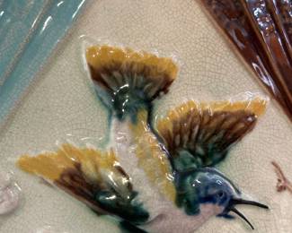 Closeup of A charming antique majolica large pitcher, 8-1/2" H, circa 1880, triangular form pitcher in bird and fan pattern of green, yellow, brown and pink, pink flowers on brown twigs, fans of brown and turquoise, crackle cream background and lavender liner. Raised English registration mark to base, likely by Banks & Thorley Pottery.