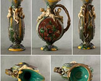 A stunning rare 1861 large hand-painted majolica ewer, 14-1/2" tall, marked Minton, known as the Palissy jug, modeled by French sculptor Hughes Protat with impressed modeler’s initials HP under handle; formed as barrel, the neck adorned with 4 festive cherubs, circular body decorated w/raised green brown vine tendrils, deep turquoise liner, prof. repair to handle.