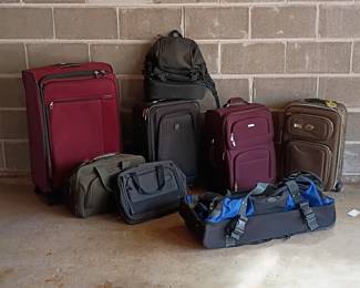 A collection of luggage including suitcases, duffels, and backpacks